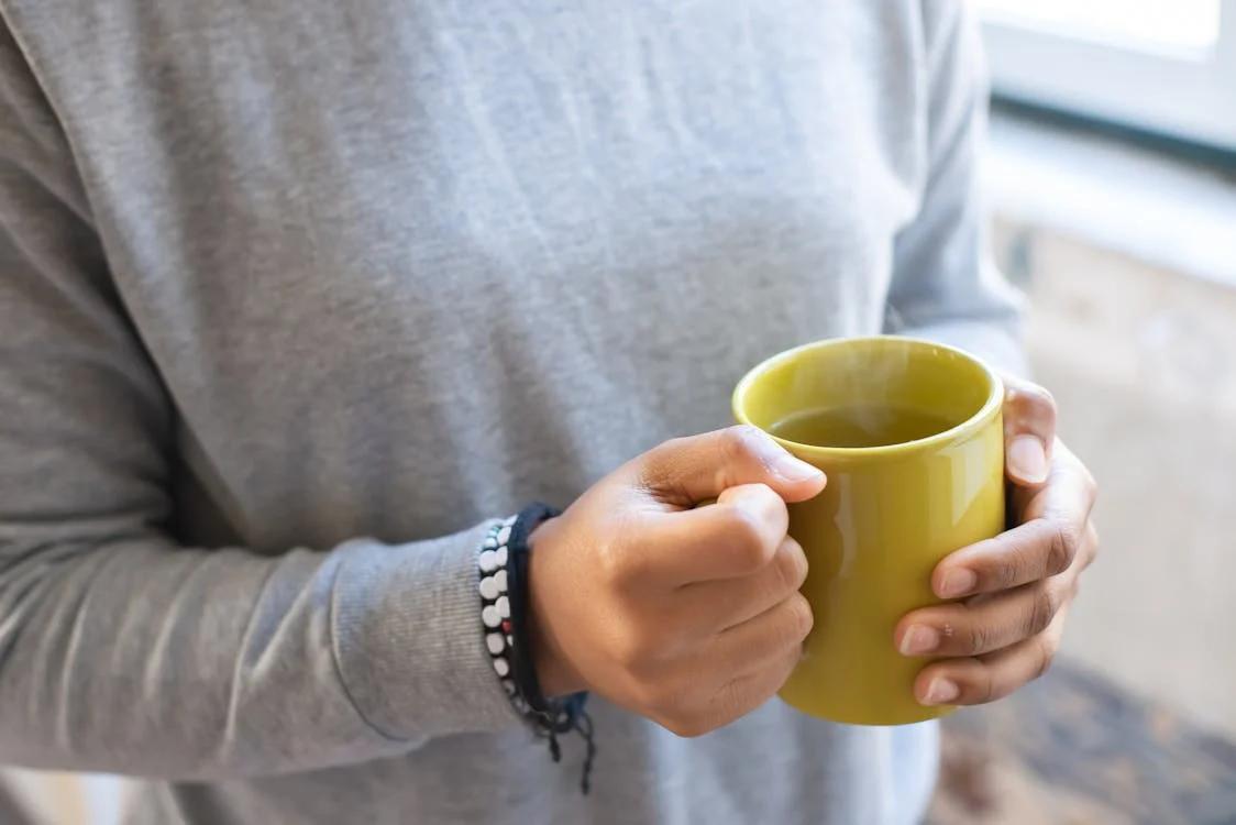 a person holding a yellow cup
