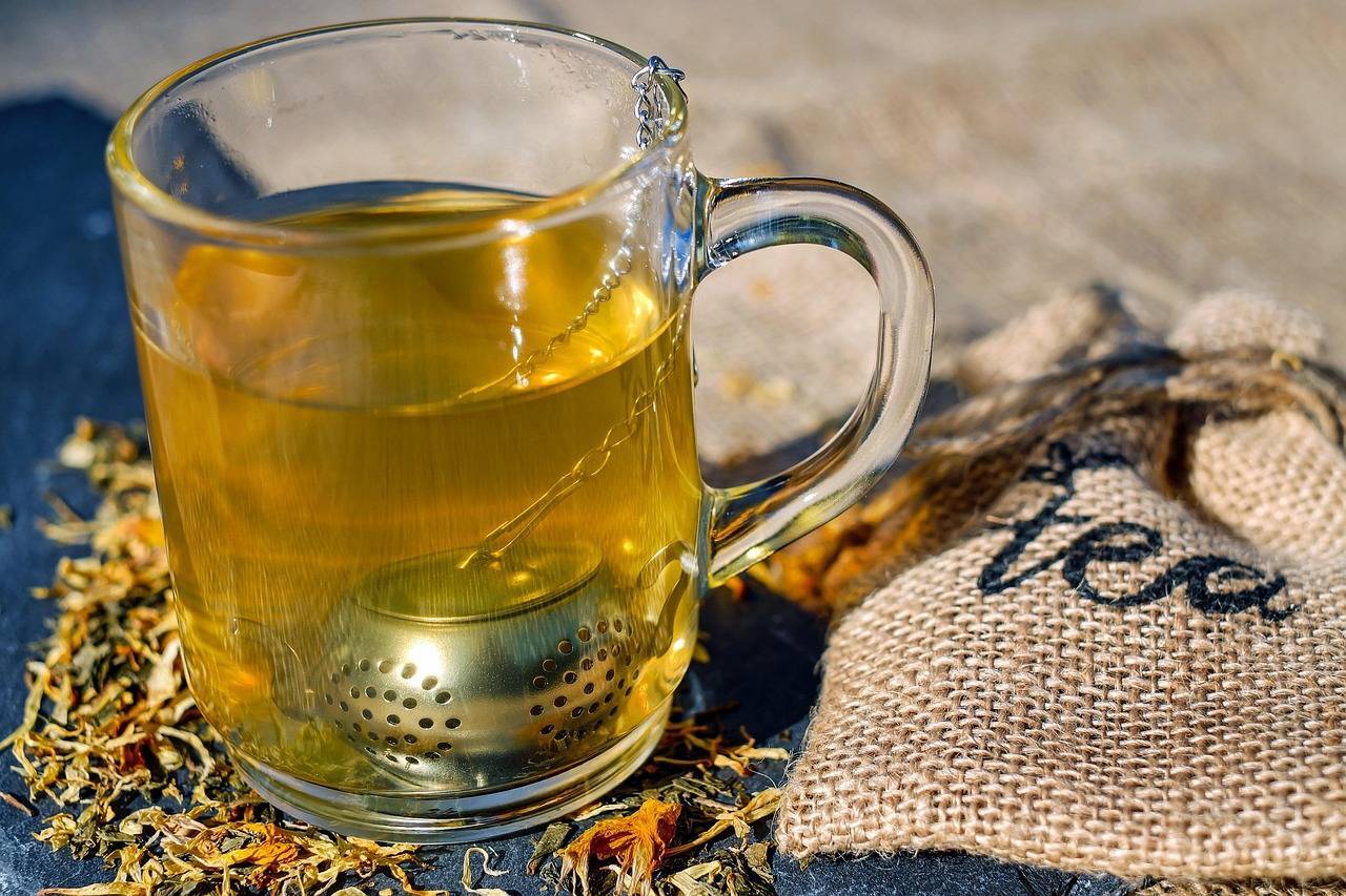Glass mug of tea with a metal infuse
