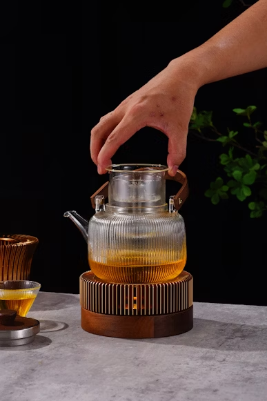 A hand is adjusting a teapot filled with tea