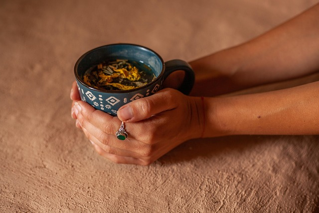 Hands holding a cup of herbal tea.