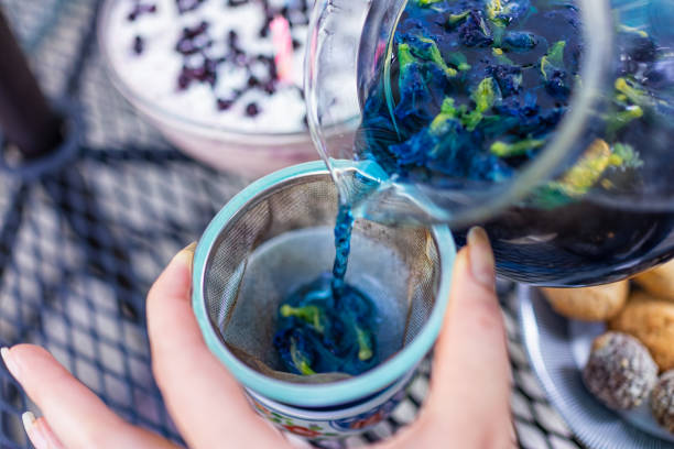 Herbal tea poured through a strainer into a cup