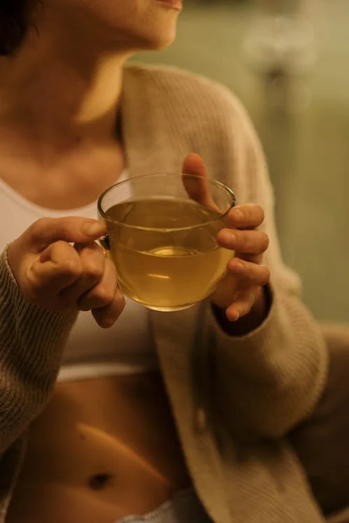 A woman holding a cup of herbal tea