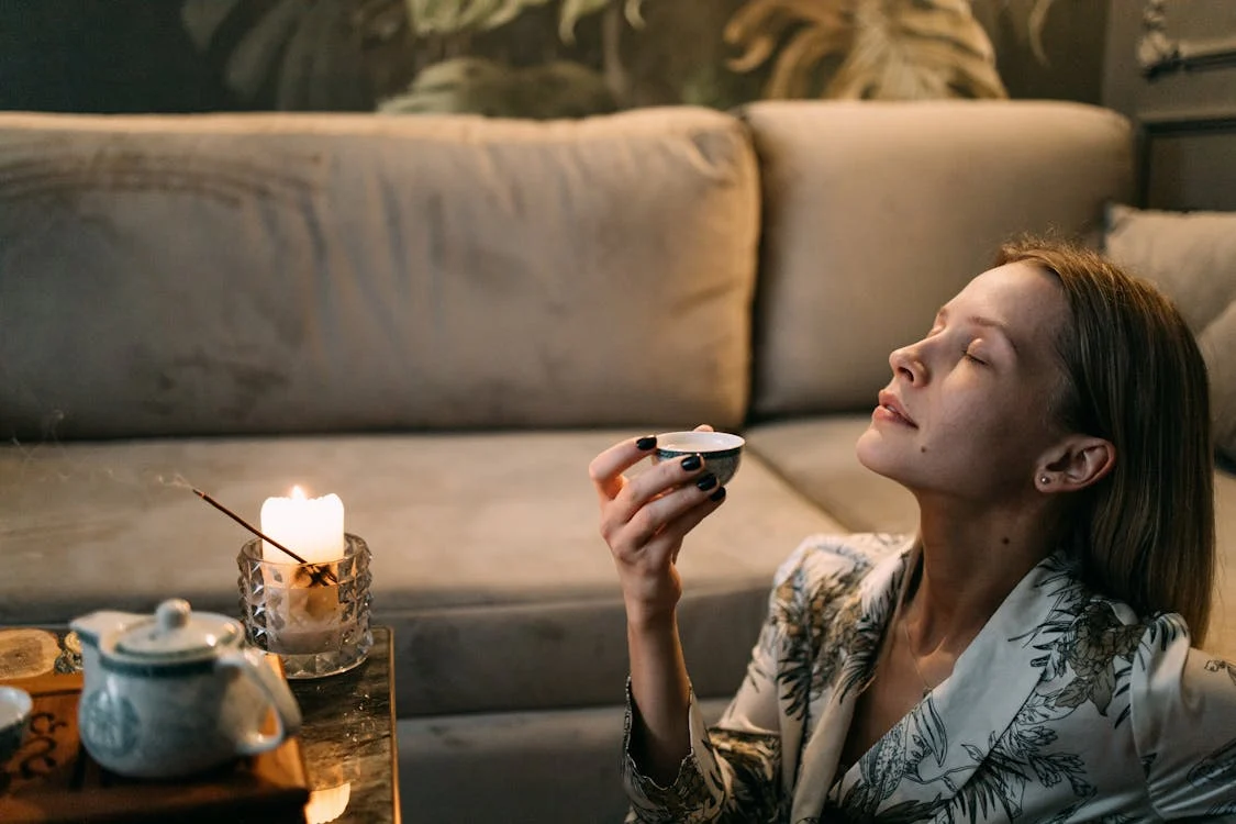Women holding a small cup with her eyes closed