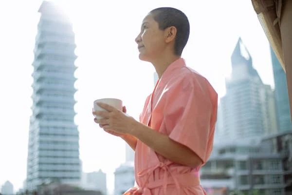 Women in pink bathrobe holding a cup of tea