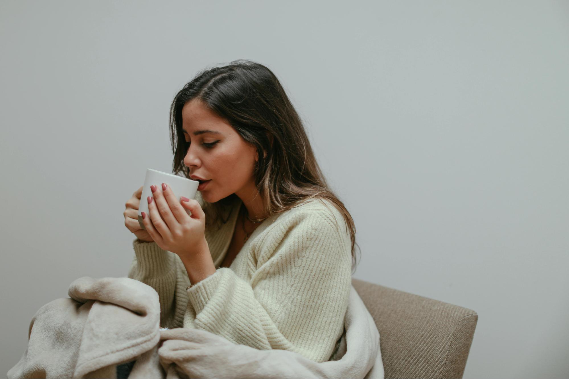 A women drinking tea from white cup