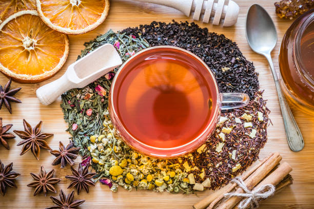 Tea cup surrounded by several kinds of dried herbs for preparing infusion