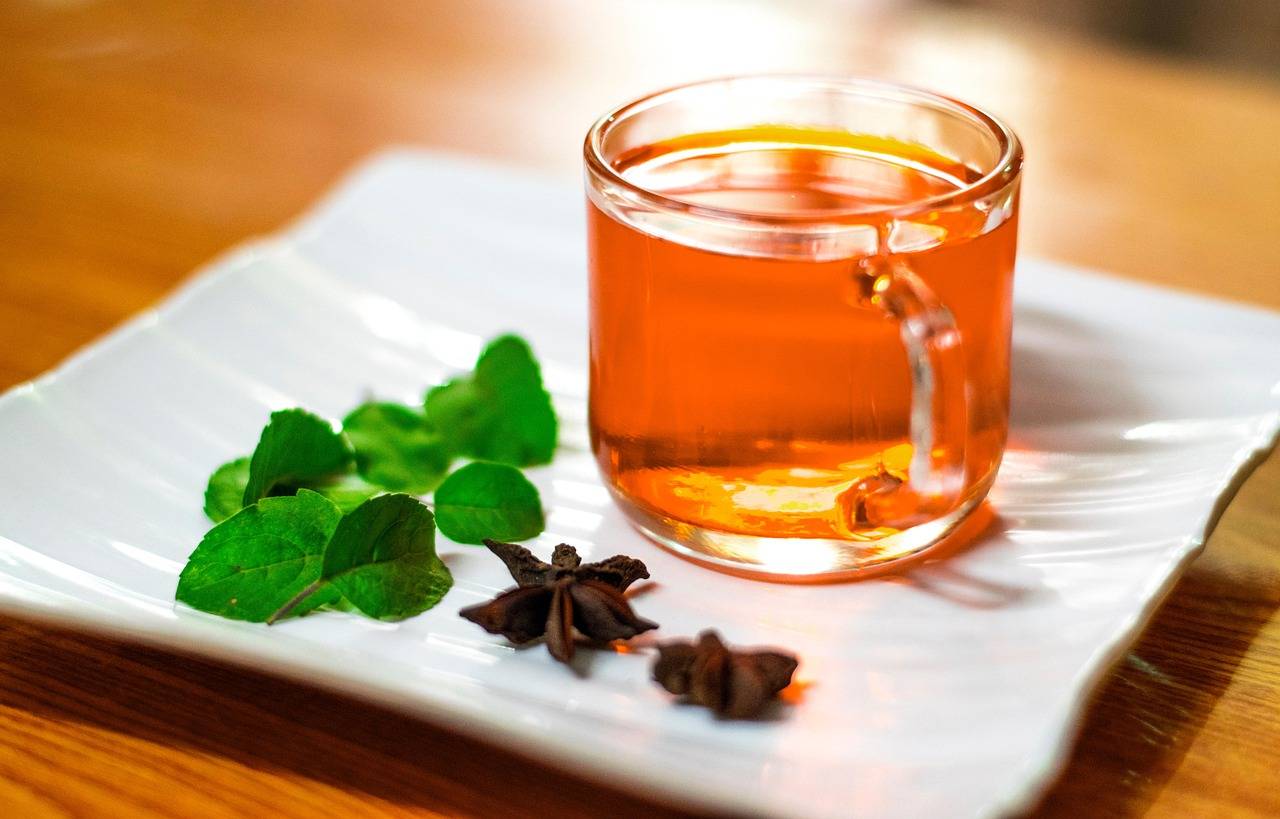 A clear glass mug of amber-colored tea